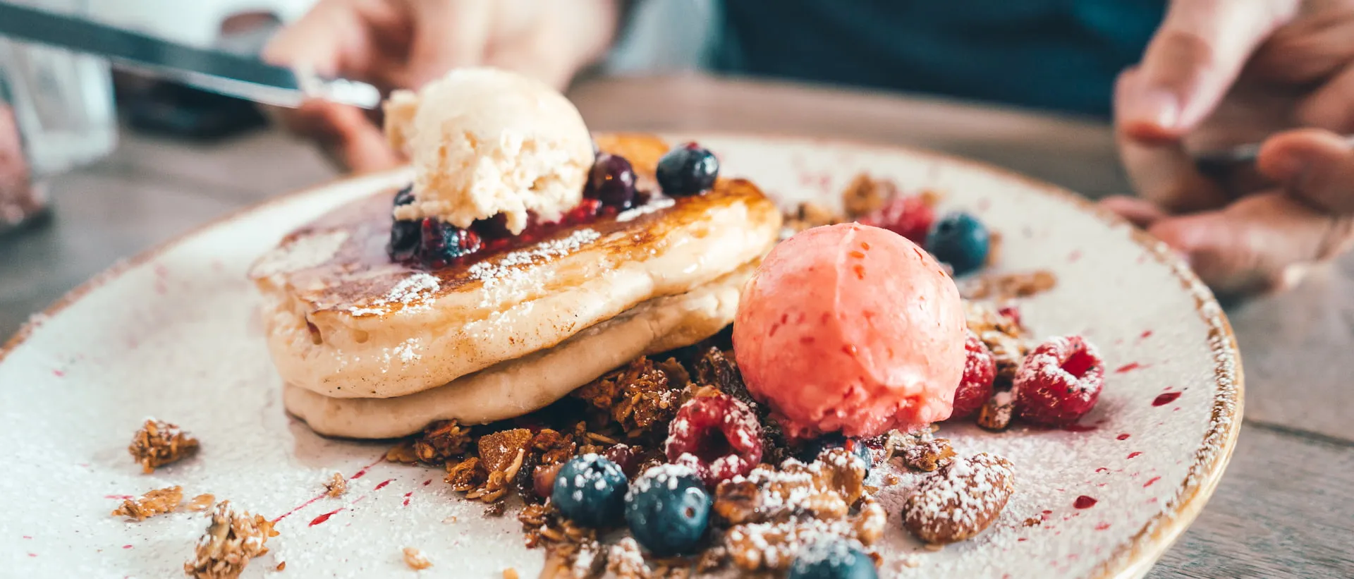 A stack of the best pancakes in Perth, topped with fruit and meringue.